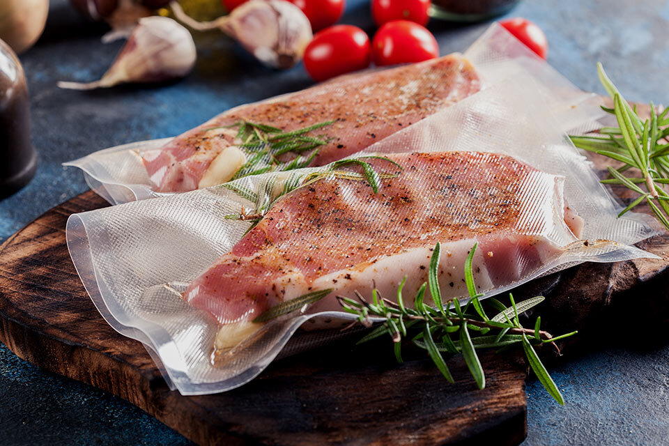 Zdjęcie kawałków mięsa zapakowanych w woreczki do gotowania próżniowego.