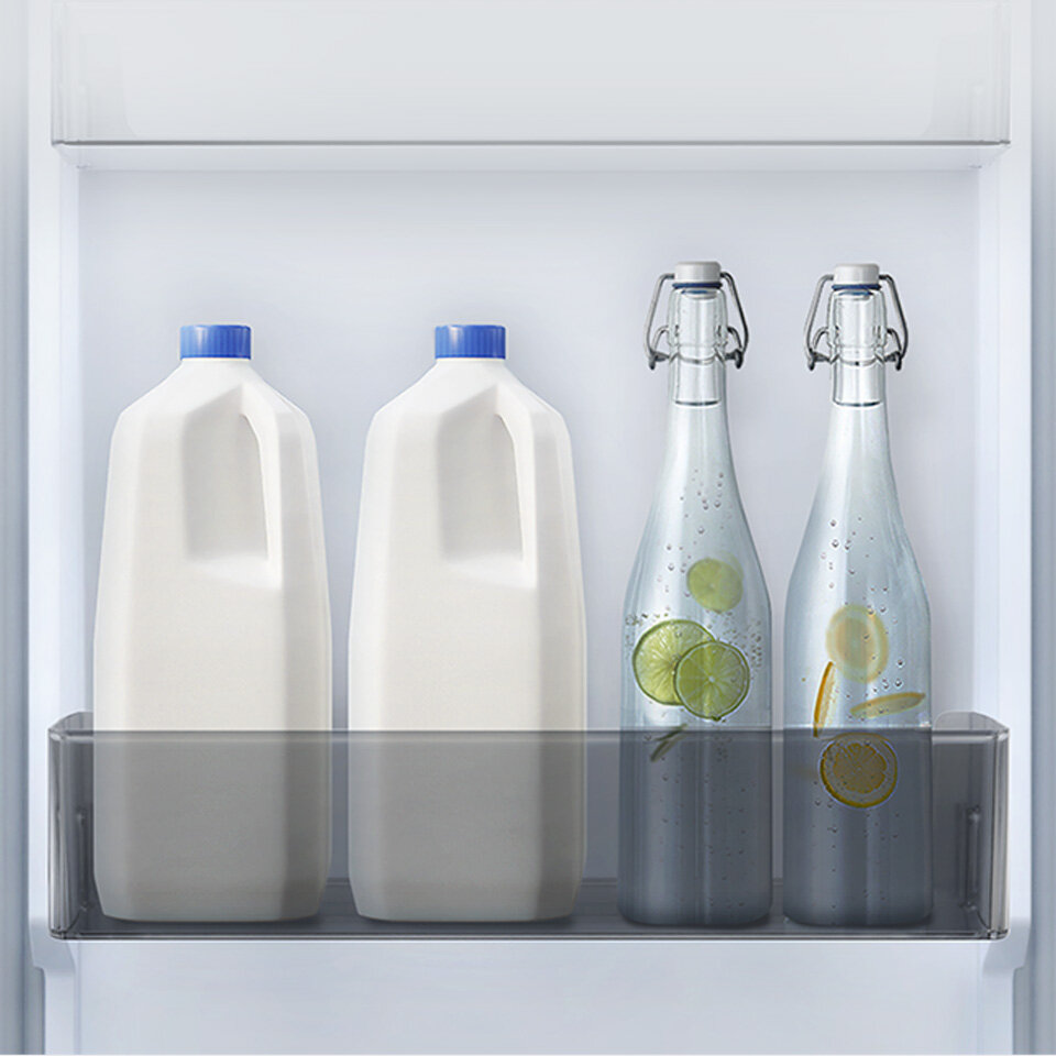 Plastikowe oraz szklane pojemniki z mlekiem i wodą umieszczone na jednym z czterech pojemników drzwiowych